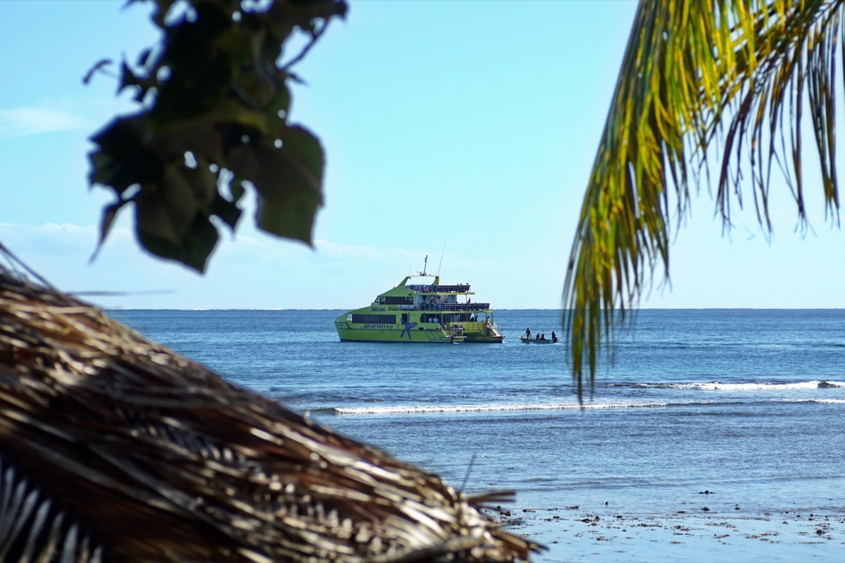 Ferry catamaran lying off a Fijian island with a tender boat alongside